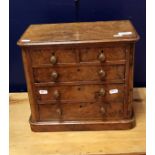 A burr walnut miniature chest of two short over three long drawers raised on a plinth base in the