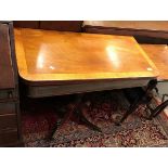 An early 19th Century mahogany tea table the cross-banded foldover top over a satinwood strung