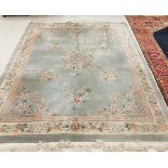 A Chinese Superwash carpet with centre floral medallion on a pale blue ground within a cream ground
