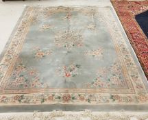 A Chinese Superwash carpet with centre floral medallion on a pale blue ground within a cream ground