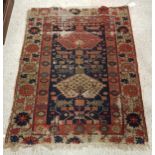 A Persian rug with two stylised lozenge shaped medallions on a foliate decorated blue ground within