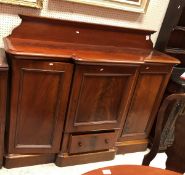 A Victorian mahogany break front sideboard of slim proportions with the raised back over a central