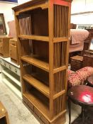 A modern hardwood bookcase of four shelves and two drawers to base