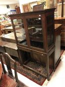 An oak cabinet on stand the two glazed doors enclosing adjustable shelving on square supports