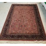 A Persian rug with all over floral decoration on a plum ground within a blue ground floral