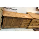 A modern pine dwarf cabinet with two cupboard doors and two drawers