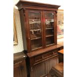 A Victorian mahogany bookcase cabinet the two glazed doors enclosing shelves over a secretaire