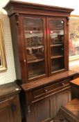 A Victorian mahogany bookcase cabinet the two glazed doors enclosing shelves over a secretaire