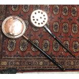 A copper warming pan with ebonised turned wood handle and another copper warming pan with engraved