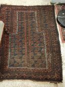 A Persian prayer rug with all over foliate medallion decoration on a red ground within a similarly