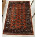 A Bokhara design rug with all over elephant foot and stylised tarantula decoration on a dark