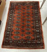 A Bokhara design rug with all over elephant foot and stylised tarantula decoration on a dark