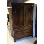 A Regency mahogany linen press with two figured panelled doors enclosing five linen shelves over