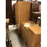 A mid 20th Century G Plan oak veneered bedroom suite comprising a pair of wardrobes,