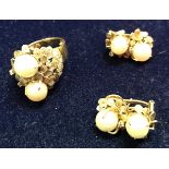 An unmarked yellow metal mid 20th Century pearl and stone set ring with stylised floral decoration