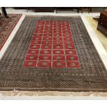 A Bokhara carpet with all over rectangular medallion decoration on a taupe ground within a stepped