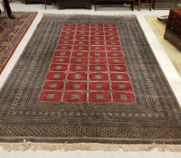 A Bokhara carpet with all over rectangular medallion decoration on a taupe ground within a stepped