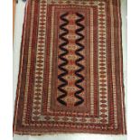 A Turkoman rug with repeating lozenge medallion decoration on a deep blue centre ground within a