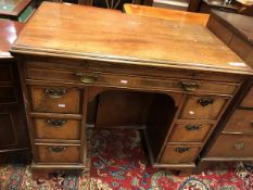 An 18th Century mahogany kneehole desk the top with molded edge above a slide with tooled writing