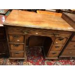 An 18th Century mahogany kneehole desk the top with molded edge above a slide with tooled writing