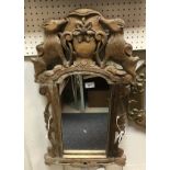A German oak framed and carved wall mirror with mountain goat or chamois decoration to the surmount