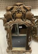 A German oak framed and carved wall mirror with mountain goat or chamois decoration to the surmount