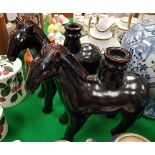 A pair of modern Chinese treacle-glazed pottery figures of horses as candlesticks,