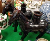 A pair of modern Chinese treacle-glazed pottery figures of horses as candlesticks,