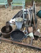 A large collection of garden tools to include a roller, an umbrella stand,