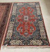 A fine Persian rug with centre medallion on a stylised leaf decorated red ground with floral spray