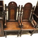 A pair of late 19th Century continental stained pine throne type hall chairs the arched panelled