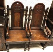 A pair of late 19th Century continental stained pine throne type hall chairs the arched panelled