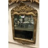 A circa 1700 carved giltwood and gesso framed wall mirror in the Rococo style