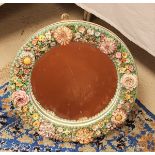 A Continental floral encrusted circular framed wall mirror in the Meissen style