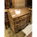 A Continental walnut and cross banded bureau with fall front over three serpentine drawers