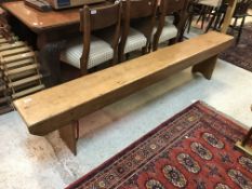 A stained pine school bench on trestle end supports