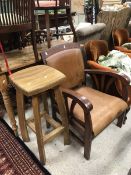 A modern leather upholstered open arm elbow chair together with a modern oak bar stool