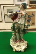 A 19th Century Continental porcelain figure of a gentleman in gilt decorated costume with dog at