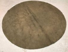 A modern circular rug of plain taupe col