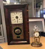 An early 20th Century brass mantel clock under a glass dome,