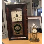 An early 20th Century brass mantel clock under a glass dome,