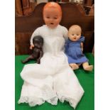 A collection of three dolls to include a Rose Bud talking doll and a black doll,
