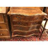 A reproduction mahogany serpentine fronted chest of four long drawers in the George III manner