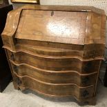 A Continental walnut and cross banded bureau with fall front over three serpentine drawers,