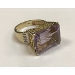 A 9 carat gold dress ring set with a large amethyst and diamonds