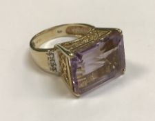 A 9 carat gold dress ring set with a large amethyst and diamonds