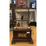 A 19th Century French Singing Bird automaton as two birds in a cage on a mahogany base with Empire