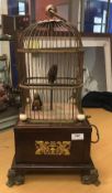 A 19th Century French Singing Bird automaton as two birds in a cage on a mahogany base with Empire