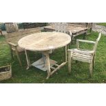 A teak garden table with two teak chairs and a bench