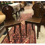 A pair of Victorian mahogany panel seated hall chairs